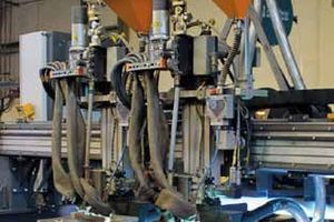 1 Two welding torches coat the base plate in parallel operation. The clamping fixtures in the foreground reduce warpage