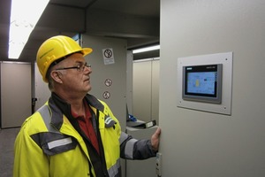 4 The head of the electrical workshop checking the cement mixtures in front of the touch panel in the control cabinet door. Not only are measured values visualized here, but direct local operation of the loss-in-weight scales is also possible
