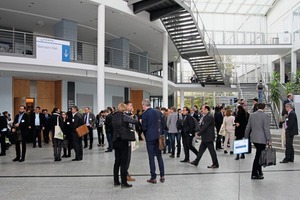 4 Conference participants discussing presentations and visiting the posters displayed in the hallway